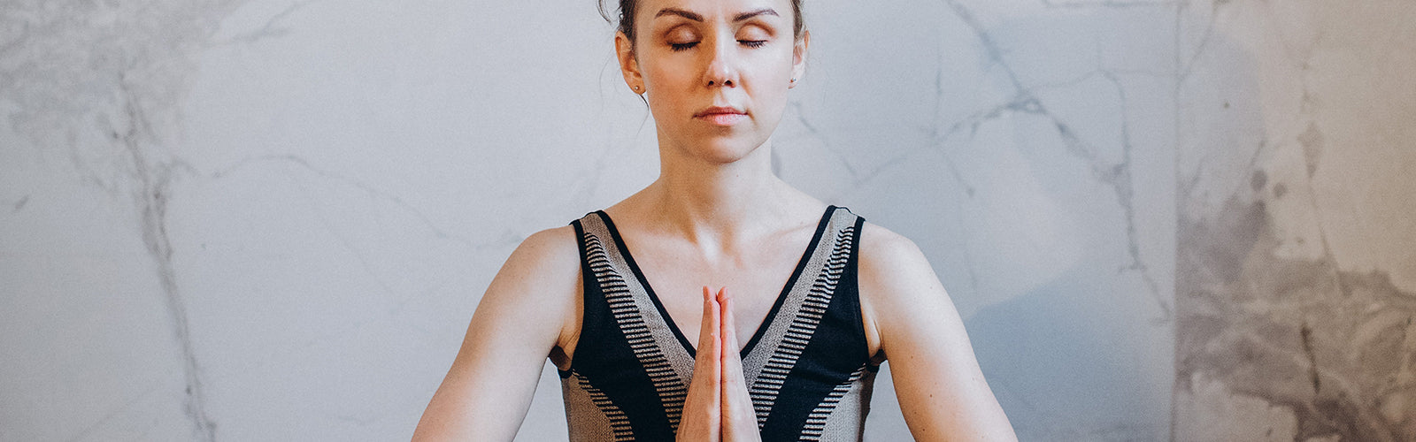 Woman sitting and meditating with hands together