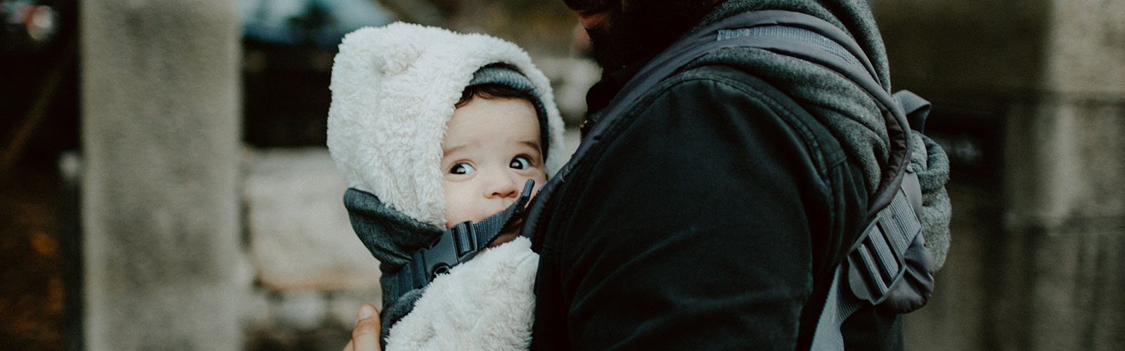 Dad carrying baby in a buckle carrier